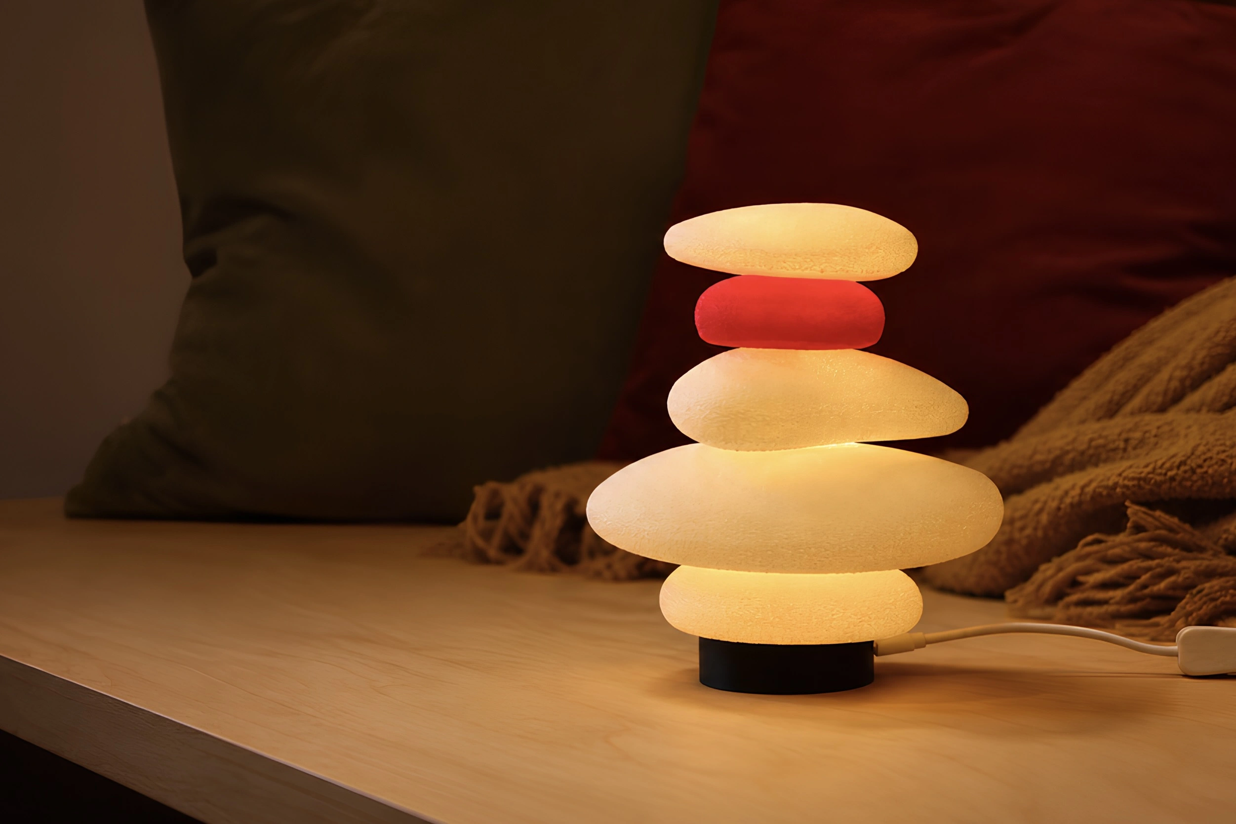 A glowing Moonstone lamp with stacked cream and red stones